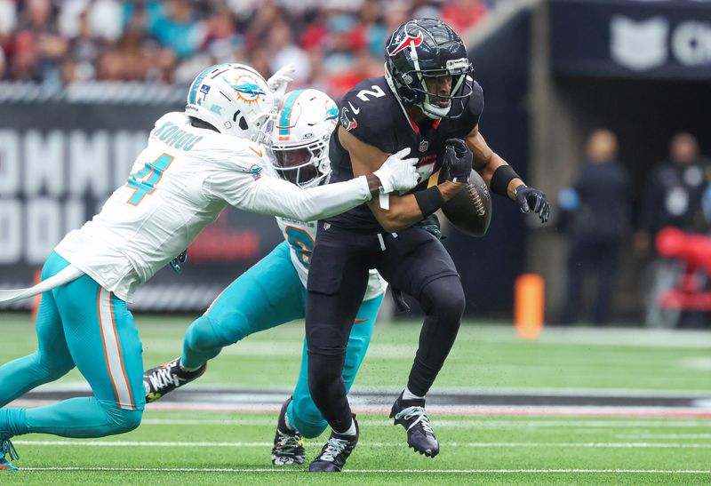 Dec 15, 2024; Houston, Texas, USA; Houston Texans wide receiver Robert Woods (2) fumbles the ball as Miami Dolphins cornerback Kader Kohou (4) defends during the first quarter at NRG Stadium. Mandatory Credit: Troy Taormina-Imagn Images