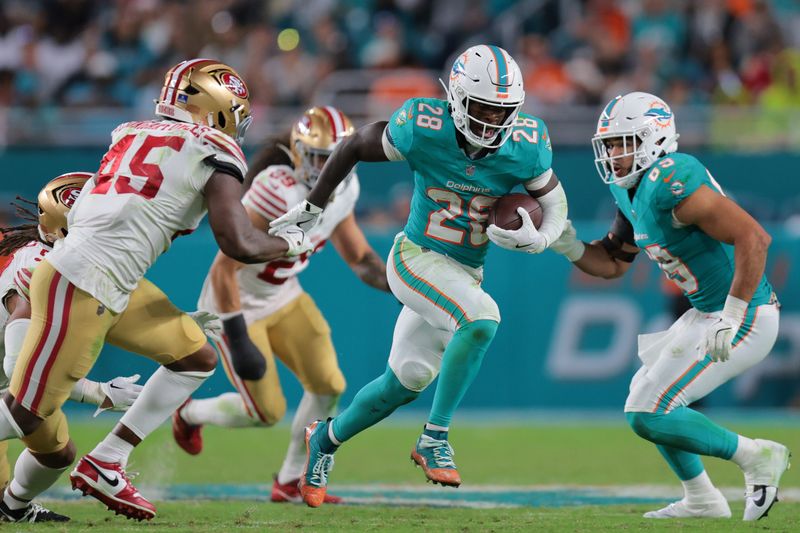 Dec 22, 2024; Miami Gardens, Florida, USA; Miami Dolphins running back De'Von Achane (28) runs with the football against the San Francisco 49ers during the fourth quarter at Hard Rock Stadium. Mandatory Credit: Sam Navarro-Imagn Images