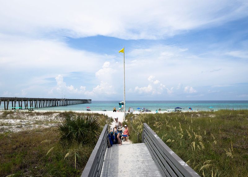 A yellow flag flies during mild surf conditions at Dog Beach near Russell-Fields Pier in Panama City Beach, Fla., July 16, 2024. (Tyler Orsburn/News Herald)