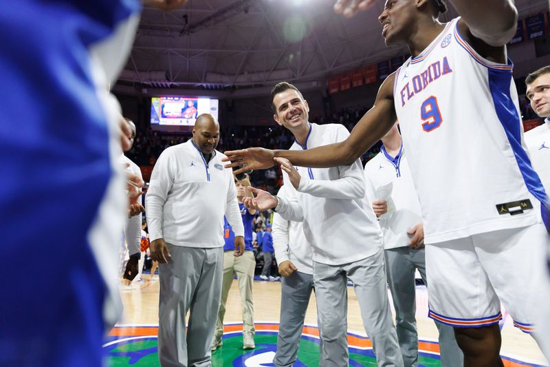 Jan 25, 2025; Gainesville, Florida, USA; Florida Gators head coach Todd Golden smiles in the huddle with Florida Gators center Rueben Chinyelu (9) after a game against the Georgia Bulldogs at Exactech Arena at the Stephen C. O'Connell Center. Mandatory Credit: Matt Pendleton-Imagn Images