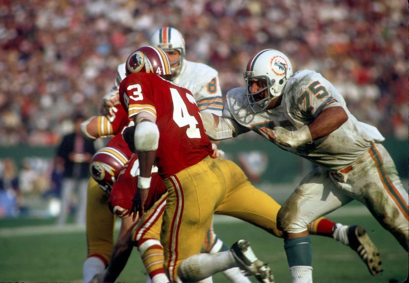 Jan 14, 1973; Los Angeles, CA, USA; FILE PHOTO; Miami Dolphins defensive tackle (75) Manny Fernandez pursues Washington Redskins runningback (43) Larry Brown during Super Bowl VII at the Los Angeles Memorial Coliseum. The Dolphins defeated the Redskins 14-7 and finishing the season a perfect 17-0. Mandatory Credit: Tony Tomsic-USA TODAY NETWORK