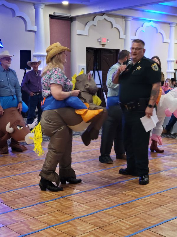 Sheriff Wayne Ivey emcees the WIld West Race at the annual Buckaroo Ball, a fundraiser for Harmony Farms. Visit harmonyfarmsinc.com.