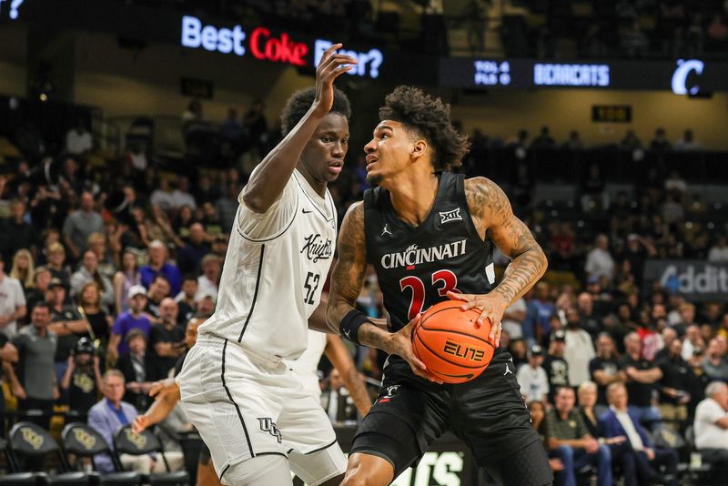 Feb 5, 2025; Orlando, Florida, USA; Cincinnati Bearcats forward Dillon Mitchell (23) goes to the basket against UCF Knights center Moustapha Thiam (52) during the first half at Addition Financial Arena. Mandatory Credit: Mike Watters-Imagn Images