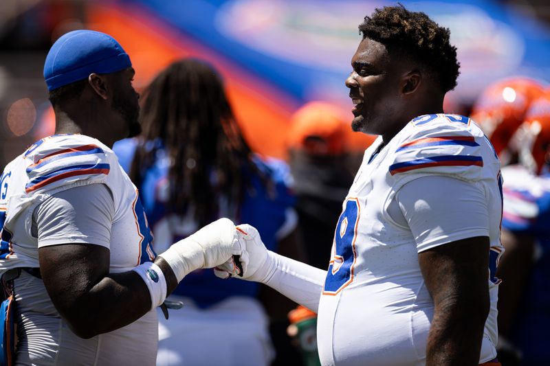 Florida Gators defensive lineman Cam Jackson (99) and Florida Gators defensive lineman Caleb Banks (88) embrace before the game at the Orange and Blue spring football game at Steve Spurrier Field at Ben Hill Griffin Stadium in Gainesville, FL on Saturday, April 13, 2024. [Matt Pendleton/Gainesville Sun]