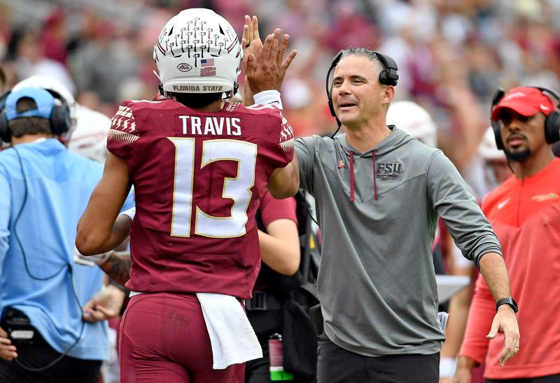 Oct 29, 2022; Tallahassee, Florida, USA; Florida State Seminoles quarterback Jordan Travis high-fives head coach Mike Norvell during the second half against the Georgia Tech Yellow Jackets at Doak S. Campbell Stadium. Mandatory Credit: 
Melina Myers-USA TODAY Sports
