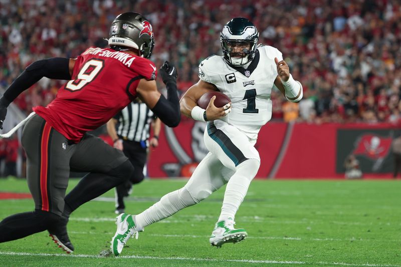 Jan 15, 2024; Tampa, Florida, USA; Philadelphia Eagles quarterback Jalen Hurts (1) runs the ball as Tampa Bay Buccaneers linebacker Joe Tryon-Shoyinka (9) defends during the first half of a 2024 NFC wild card game at Raymond James Stadium. Mandatory Credit: Kim Klement Neitzel-USA TODAY Sports