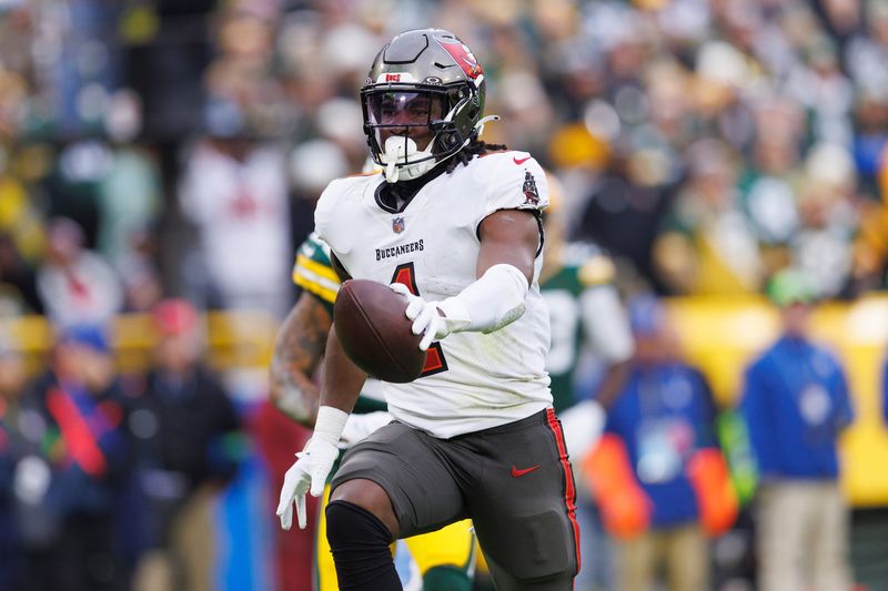 Dec 17, 2023; Green Bay, Wisconsin, USA; Tampa Bay Buccaneers running back Rachaad White (1) holds the ball out while scoring a touchdown during the third quarter against the Green Bay Packers at Lambeau Field. Mandatory Credit: Jeff Hanisch-USA TODAY Sports