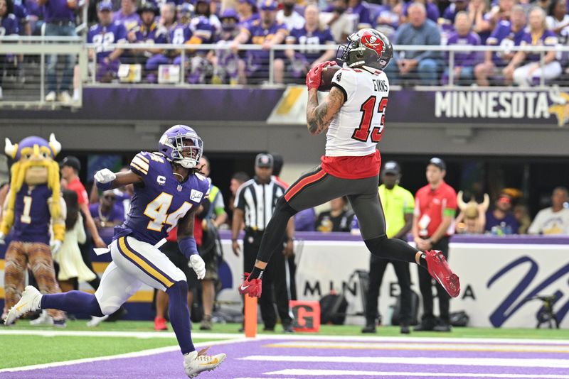 Sep 10, 2023; Minneapolis, Minnesota, USA; Tampa Bay Buccaneers wide receiver Mike Evans (13) catches a touchdown pass from quarterback Baker Mayfield (not pictured) as Minnesota Vikings safety Josh Metellus (44) defends during the second quarter at U.S. Bank Stadium. Mandatory Credit: Jeffrey Becker-USA TODAY Sports
