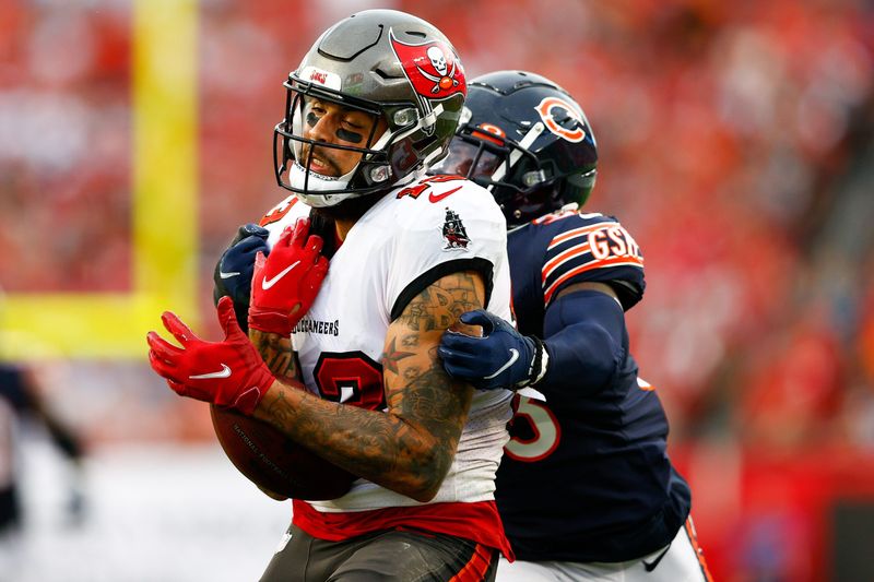Oct 24, 2021; Tampa, Florida, USA; Tampa Bay Buccaneers wide receiver Mike Evans (13) catches a pass in the first half while defended by Chicago Bears cornerback Jaylon Johnson (33) at Raymond James Stadium. Mandatory Credit: Nathan Ray Seebeck-USA TODAY Sports