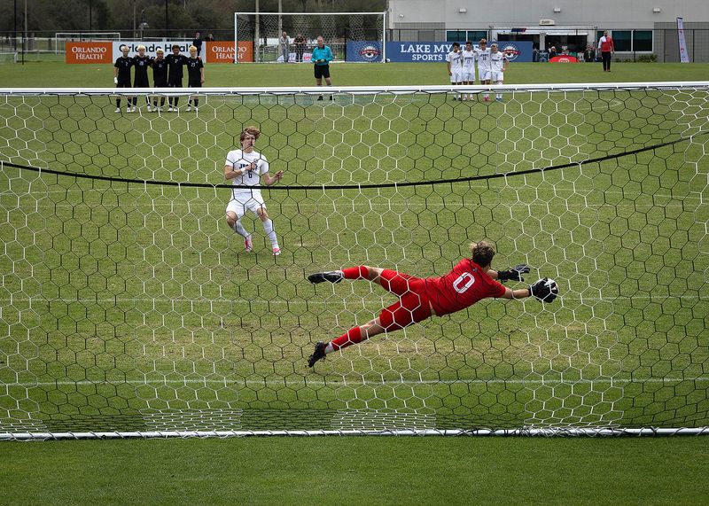 Arnold’s Lincoln Guynn blocks a penalty kick by Jesuit’s Charles Dowman during their Class 5A state championship game in Auburndale, Fla., Feb. 22, 2025. Arnold won the game penalties 4-3. (Tyler Orsburn/News Herald)