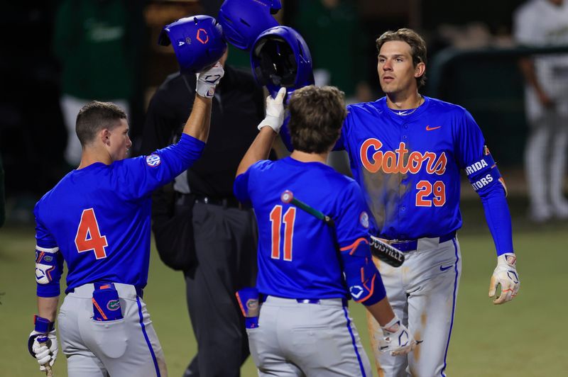 Florida catcher Brody Donay (29) taps helmets with infielder Cade Kurland (4) and infielder Brendan Lawson (11) after a solo home run during the fifth inning of an NCAA baseball matchup Monday, Feb. 17, 2025 at Jacksonville University in Jacksonville, Fla. Florida defeated Jacksonville 10-4. [Corey Perrine/Florida Times-Union]