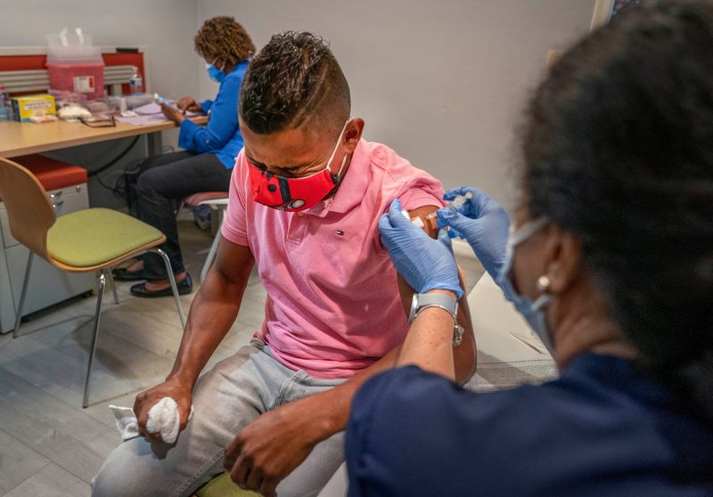 Ever Torres gets vaccinated for COVID-19 by county health department nurse Orlyn Grace at the Guatemala Maya Center in Lake Worth, Florida on August 13, 2021.