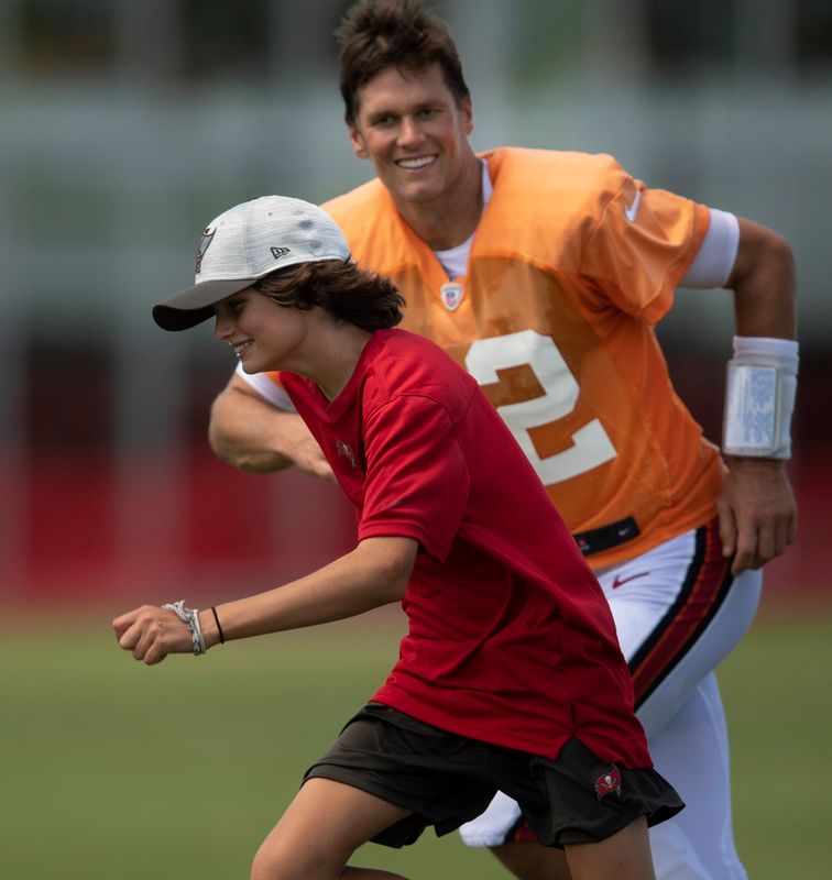 Tampa Bay Buccaneers quarterback Tom Brady (12) chases his son Jack across the field after a joint training camp practice against the Tennessee Titans at AdventHealth Training Center Thursday, Aug. 19, 2021 in Tampa, Fla.