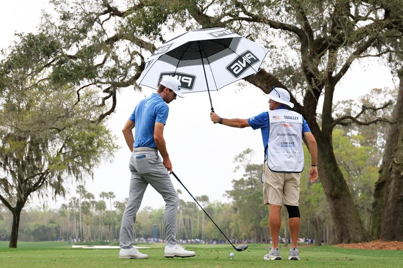 Alex Smalley is given a hand from caddie Don Donatello as he shields him from the first drops of rain on the afternoon before teeing off on the sixth hole during the final round of The Players Championship PGA golf tournment Sunday, March 16, 2025 at TPC Sawgrass in Ponte Vedra Beach, Fla. [Corey Perrine/Florida Times-Union]