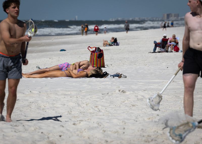 Sunbathers are seen at Russell-Fields Pier in Panama City Beach, Fla., March 17, 2025, St. Patrick's Day. (Tyler Orsburn/News Herald)
