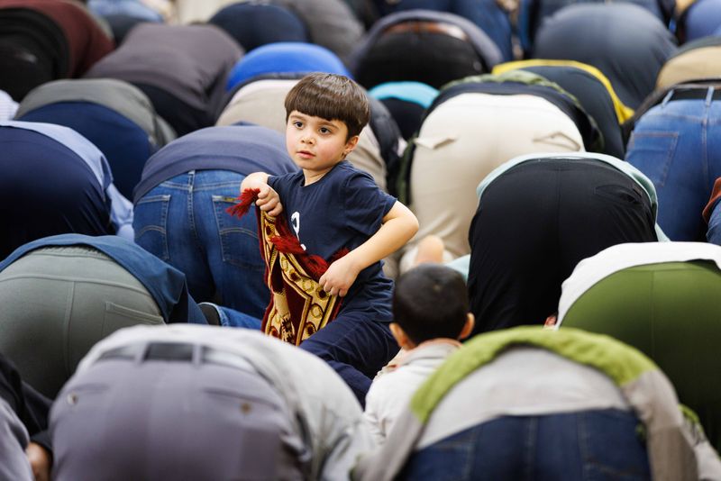 A child plays while men pray in the mosque at Islamic Society of Michiana before an iftar during Ramadan on Friday, March 14, 2025, in South Bend.