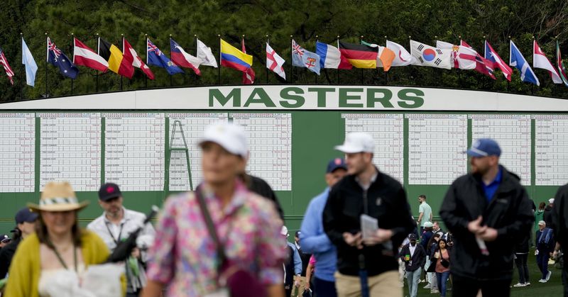 Apr 7, 2025; Augusta, Georgia, USA; Patrons walk onto the course near the Masters scoreboard during a practice round for the Masters Tournament at Augusta National Golf Club. Mandatory Credit: Michael Madrid-Imagn Images