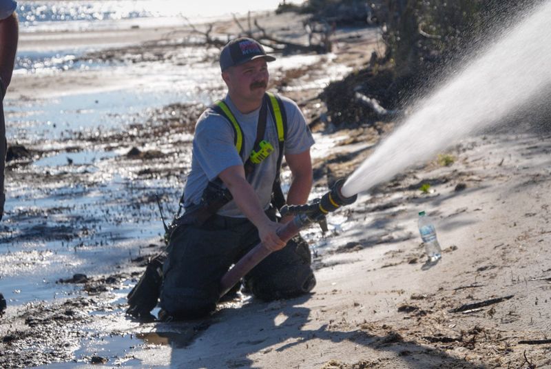 A firefighter with the Springfield Fire Rescue works to extinguish a brush fire in Parker, Florida, on April 13, 2025.