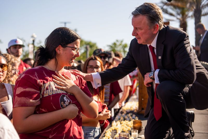 Florida State University President Richard McCullough comforts a student during a vigil after a shooter killed two and injured six at the student union building, Friday, April 18, 2025.