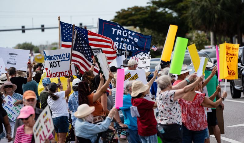 Protesters take part in a No Tyrants-No Kings rally on U.S. 41 just south of Daniels Parkway in Fort Myers on Saturday, April 19, 2025. They were protesting policies instituted by President Donald Trump.