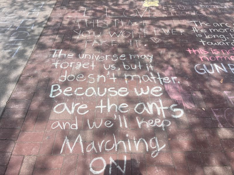 FSU students wrote messages on the sidewalk outside of the student union on April 22 after a mass shooter claimed the lives of two and injured five on the campus April 17.