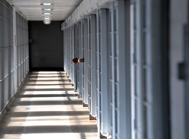 An inmate hangs his hands outside his cell as he chats with another prisoner in a nearby cell at the Taylor County Jail in Texas, June 20, 2019. Federal data show three deaths at the facility between Oct. 1, 2015 and Dec. 31, 2019.