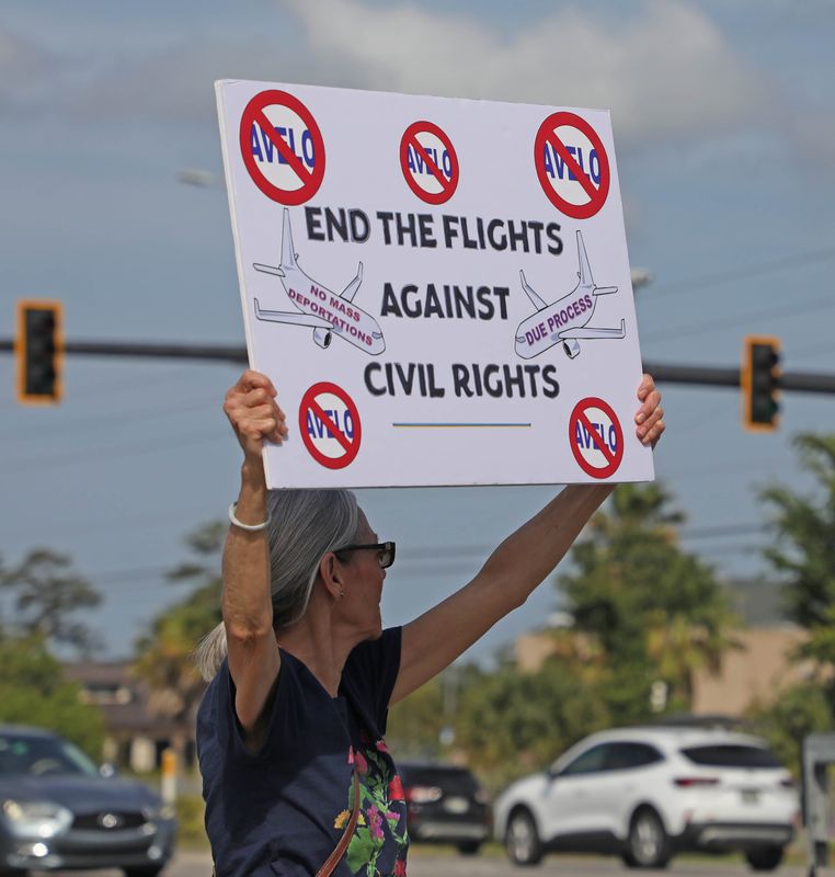Protesters stand united, holding up their signs and flags while voicing outrage over Avelo Airlines contract to fly deported immigrants to Central America. Saturday, April 26, 2025.