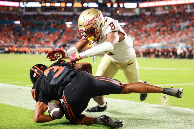 MIAMI GARDENS, FLORIDA - OCTOBER 26: Defensive back Azareye'h Thomas #8 of the Florida State Seminoles pushes wide receiver Jacolby George #3 of the Miami Hurricanes out of bounce during the second half at Hard Rock Stadium on October 26, 2024 in Miami Gardens, Florida. (Photo by Carmen Mandato/Getty Images)