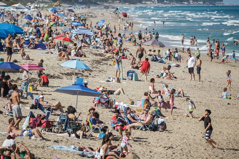 Tourism development councils such as Discover The Palm Beaches drive hundreds of thousands of visitors to the county's coastal areas each year, like these beachgoers in the sand near the William O. Lockhart Pier in Lake Worth Beach in March 2021.