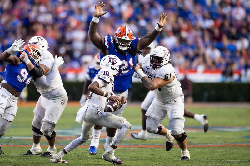 Sep 14, 2024; Gainesville, Florida, USA; Florida Gators defensive lineman Desmond Watson (21) attempts to tackle Texas A&M Aggies quarterback Marcel Reed (10) during the second half at Ben Hill Griffin Stadium. Mandatory Credit: Matt Pendleton-Imagn Images