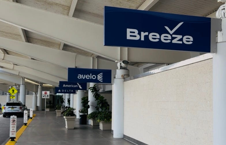 A sign for Breeze Airways can be seen in front of the passenger terminal at Daytona Beach International Airport on April 21, 2025. The ultra low-cost carrier on Wednesday, May 7, announced plans to add a new route: twice-weekly nonstop flights from Daytona to Akron-Canton, Ohio on Wednesdays and Saturdays beginning Sept. 3. Breeze also flies twice-a-week nonstop from Daytona to Hartford, Connecticut, White Plains, New York, Raleigh-Durham, North Carolina, and Providence, Rhode Island.