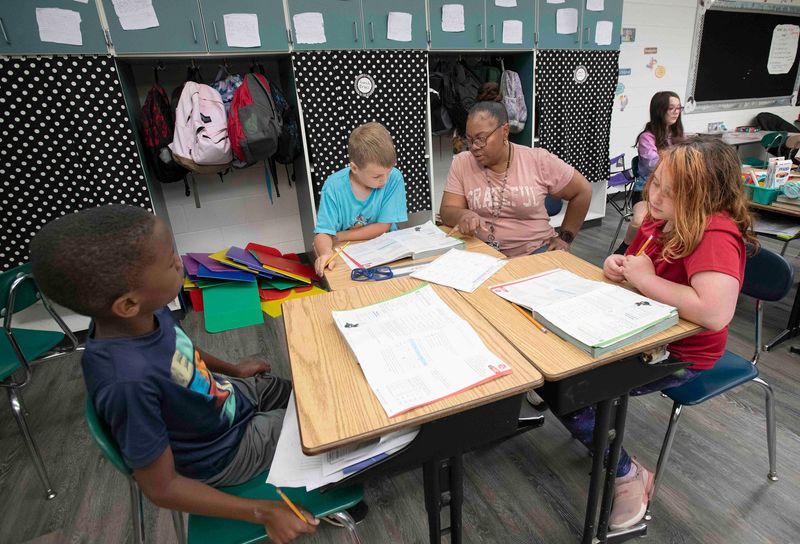N.B. Cook teacher Majorca Kelley works a group of fourth-grade students during a math assignment on May 7, 2025.