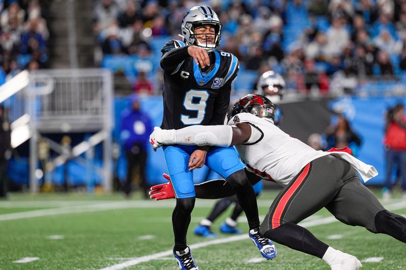 Dec 1, 2024; Charlotte, North Carolina, USA; Carolina Panthers quarterback Bryce Young (9) is tackled after the pass by Tampa Bay Buccaneers linebacker Yaya Diaby (0) during the second half at Bank of America Stadium. Mandatory Credit: Jim Dedmon-Imagn Images