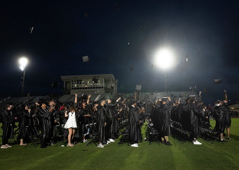 Rosenwald High School graduates throw their caps into the air after their commencement ceremony at Tommy Oliver Stadium in Panama City, Fla., May 16, 2025. (Tyler Orsburn/News Herald)