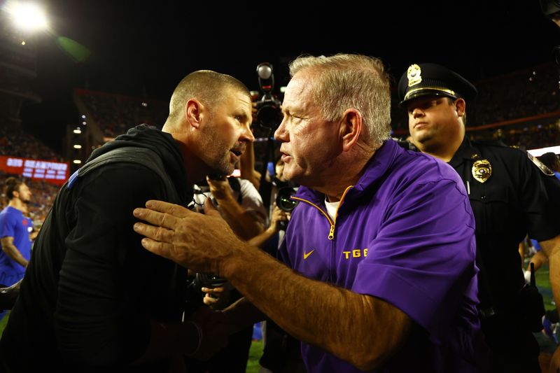 Nov 16, 2024; Gainesville, Florida, USA; LSU Tigers head coach Brian Kelly and Florida Gators head coach Billy Napier greet after the game at Ben Hill Griffin Stadium. Mandatory Credit: Kim Klement Neitzel-Imagn Images