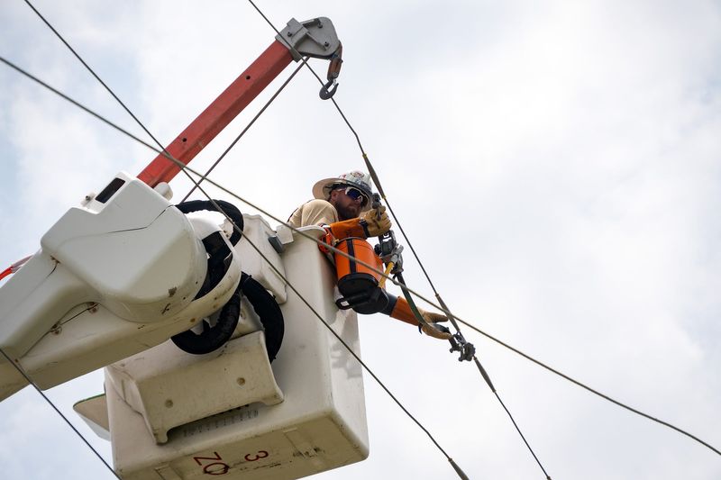 A lineman in training works on faux power lines at Florida Power and Light's Panama City, Florida office on May 21, 2025.