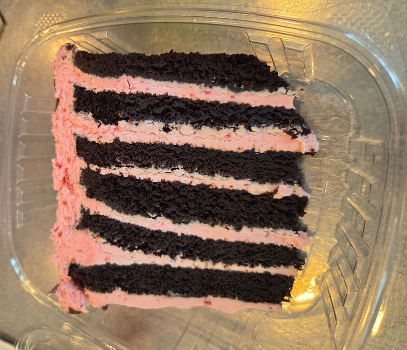 A thick slice of chocolate cake with raspberry frosting at Aioli, a Michelin Guide Bib Gourmand winner.