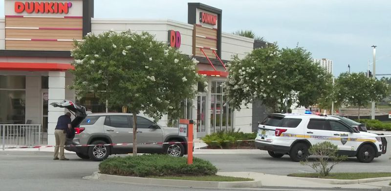Jacksonville police work the scene of a drive-thru shooting at the Gate Parkway Dunkin' Donuts on May 27, 2025.