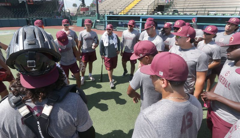 Coach Jonathan Hernandez, center, leans on a bat while talking with the Bethune-Cookman University baseball team, Wednesday, May 28, 2025, as it started practice at Jackie Robinson Ballpark before leaving for the NCAA Tournament.