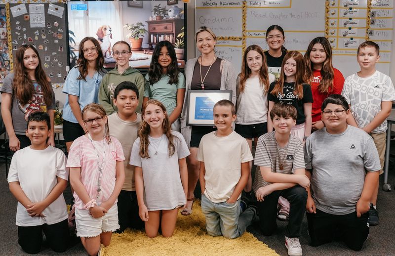 Rochelle Hilston shares her Ripple Effect Teacher Award with her English language arts students at Woodland Middle School.
