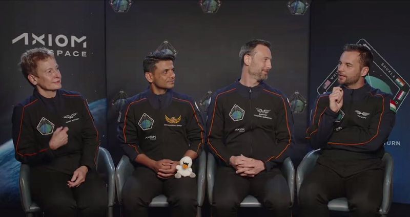 Plush swan, Joy, sits on the lap of mission pilot, Shubhanshu Shukla from India. Joy is not just the zero-g indicatior for the Axiom Mission 4 (Ax-4), but a symbolism for the name of the new SpaceX Dragon. Screenshot from the June 3 press conference.