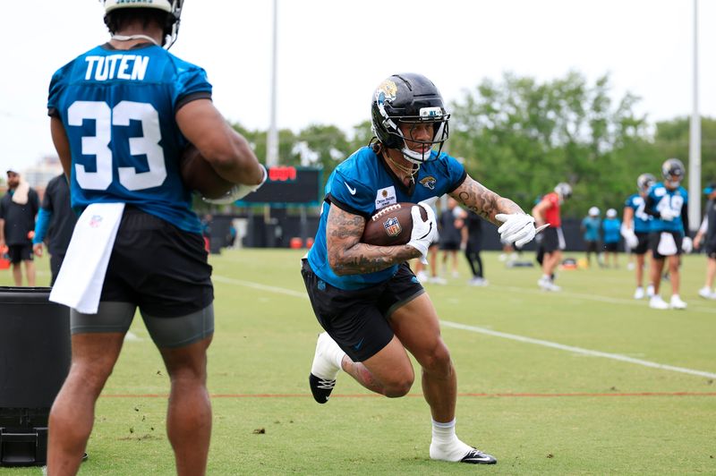 Jacksonville Jaguars running back LeQuint Allen (36) runs the ball as running back Bhayshul Tuten (33) looks on during a rookie minicamp at Miller Electric Center Saturday, May 10, 2025 in Jacksonville, Fla. [Corey Perrine/Florida Times-Union]