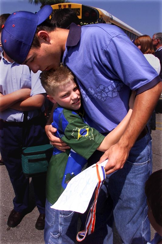 Anthony Gonyer, 9 a King's Academy third grader hugs King's Academy Senior Gator Brooks congradulating him after the baseball team arrived back from Tampa. They won the 2001 FHSAA Florida Baseball finals in the 2A division.