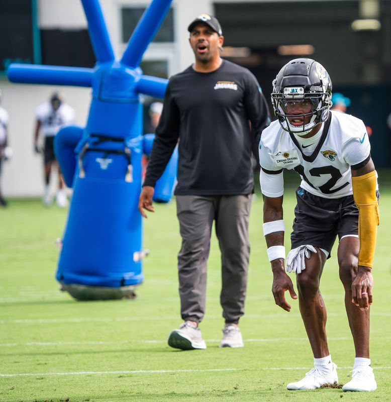 Defensive backs coach Anthony Perkins barks out orders as Travis Hunter (12) prepares to run a drill during the Jaguars’ mandatory minicamp.