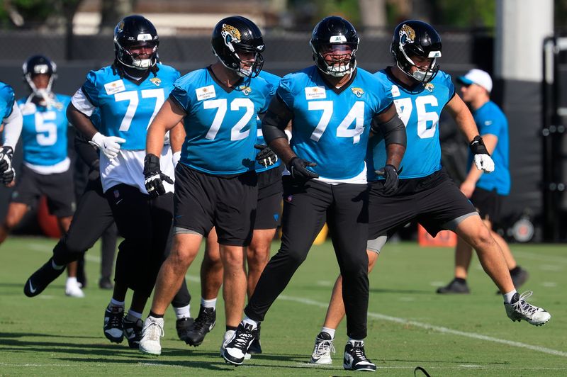 Jacksonville Jaguars offensive tackle Anton Harrison (77), offensive tackle Walker Little (72), offensive tackle Fred Johnson (74), and guard Ezra Cleveland (76) warm up during the second mandatory minicamp at Miller Electric Center Wednesday, June 11, 2025 in Jacksonville, Fla.