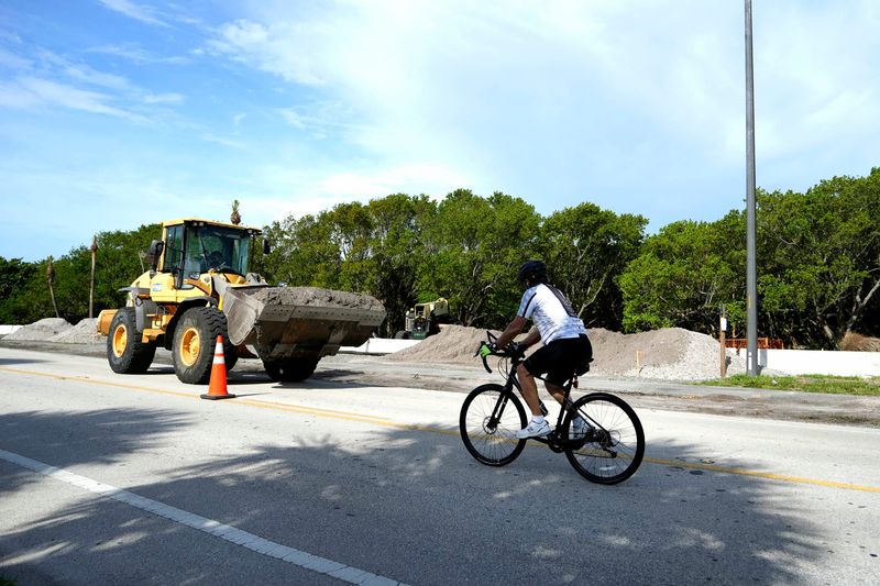 A bicyclist travels along State Road A1A as contractors for the Florida Department of Transportation work on a project that extends from Lake Avenue to just north of Ibis Way in Palm Beach on June 11.