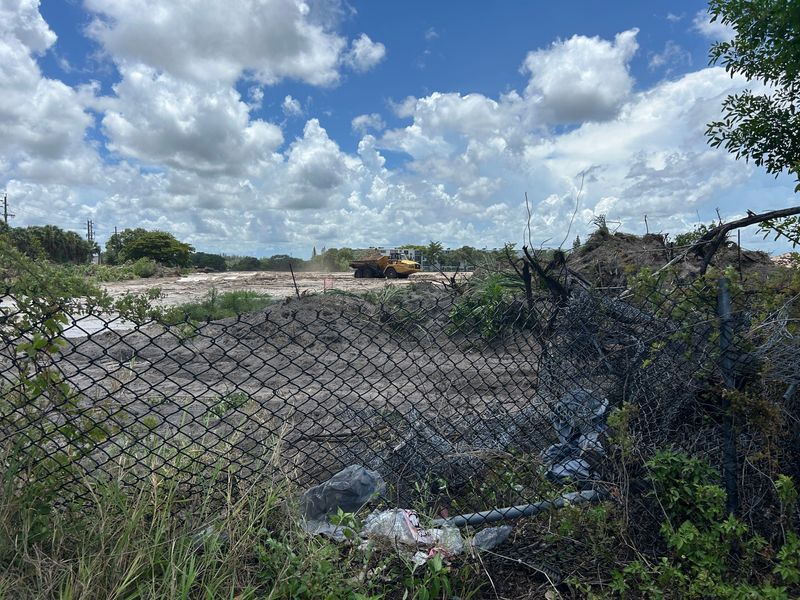 Crews clear land near Century Village, where a DR Horton townhome development is planned. A recent homeless encampment on the site  created concern among residents of the senior community.