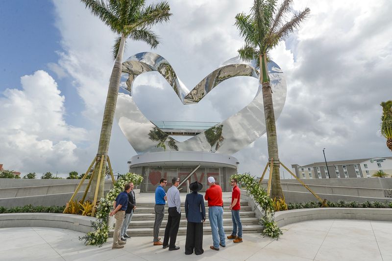 Internationally acclaimed artist JEFRË, of Orlando, cuts a ribbon during a private ceremony by Mattamay Homes to unveil his Heart in the Park sculpture, reportedly the world’s tallest heart sculpture, on June 12, 2025, within the Tradition community in Port St. Lucie. Approximately 15 couples raised their glasses for a toast in a mass marriage or re-dedication ceremony at the base of the sculpture during the private ceremony. “Through COVID, through different elections, through a lot of diversity that we finally celebrate this idea of love that really pierces through all of that and helps us connect together again as a community,” JEFRË said.