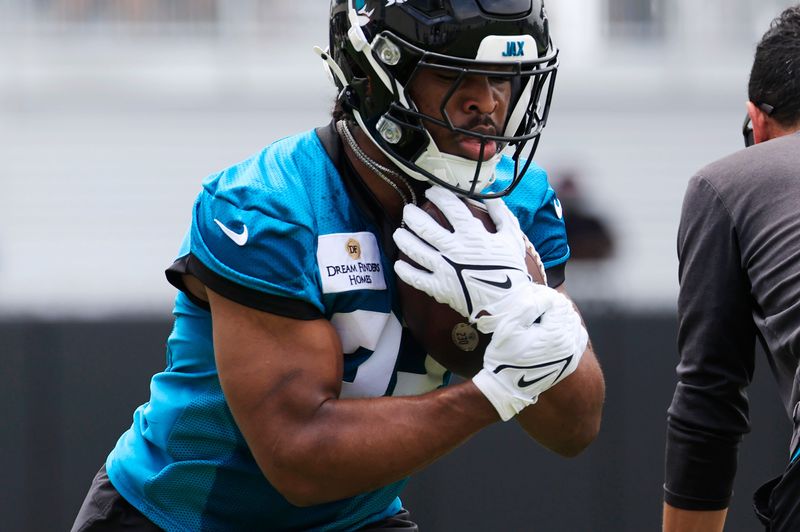 Jacksonville Jaguars running back Bhayshul Tuten (33) runs the ball during a rookie minicamp at Miller Electric Center Saturday, May 10, 2025 in Jacksonville, Fla. [Corey Perrine/Florida Times-Union]
