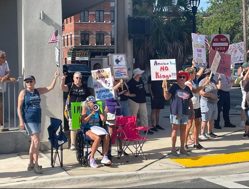 Protesters hold signs in downtown Ocala on June 14, 2025 during the nationwide "No Kings" rally. Local organizers said the protest, one of many nationwide adopting the "No Kings" theme, was meant to "show grass-roots support for vital causes and agencies which are being recklessly dismantled by the Trump administration."